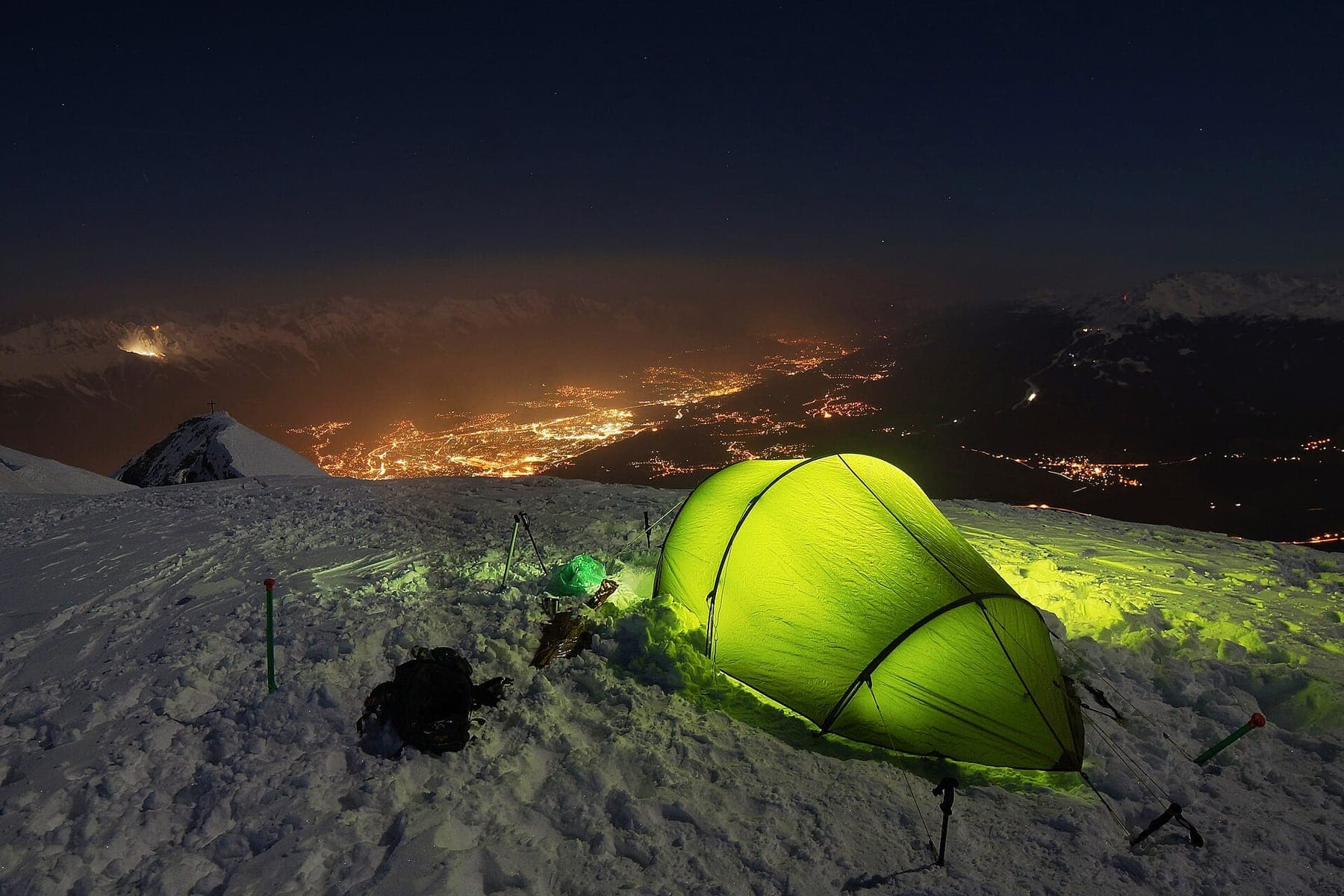 A packed duffel, folded tent and water bottle laid out on open ground before a trip