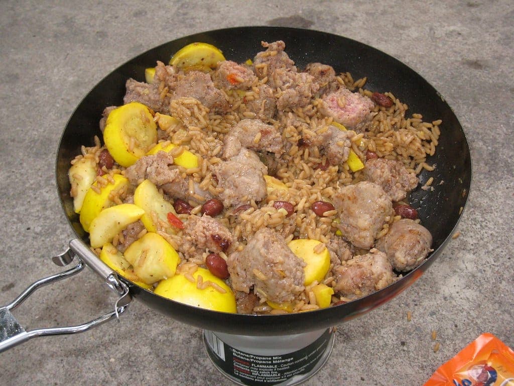 A nesting camp cookware set beside a camp stove