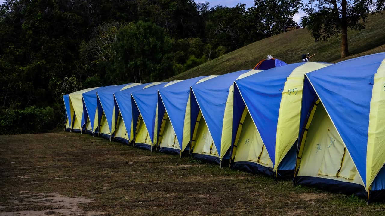 A dome tent pitched on flat ground at a cold-weather campsite