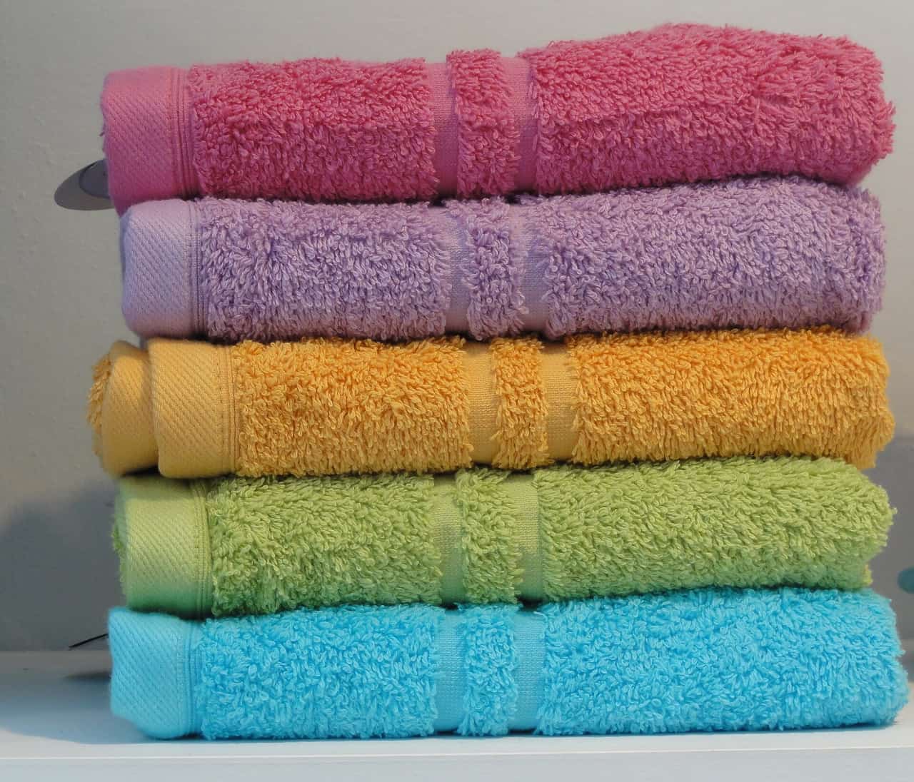 A folded quick-drying travel towel beside packed luggage