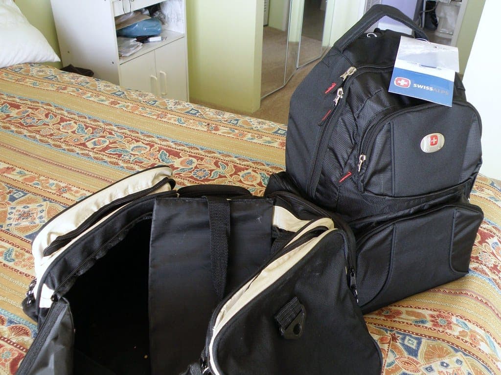 Carry-on essentials laid out beside a small bag and a passport