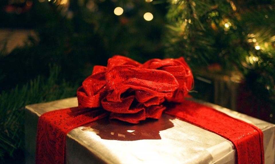 A wrapped gift box on a plain wooden surface