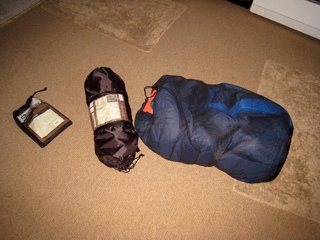 A compressed down sleeping bag beside a bulkier synthetic bag